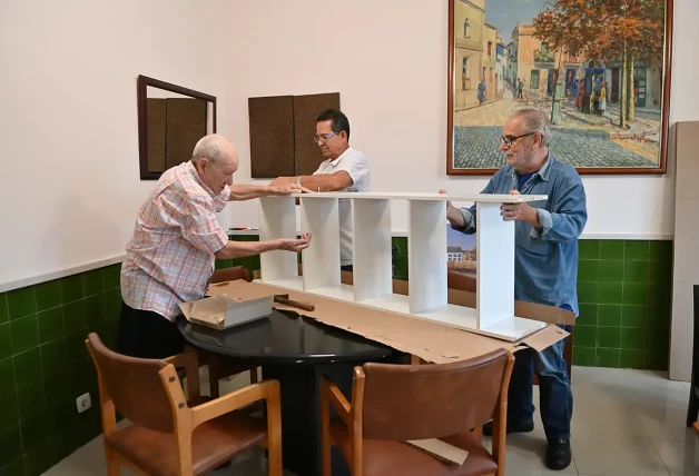 Pepe, Luis y Joan, montando una estantería para una de las zonas comunitarias.