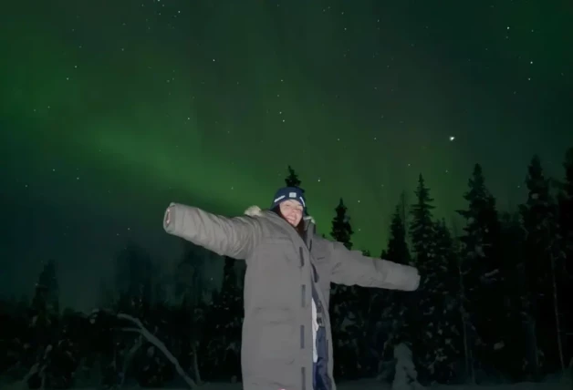 Laura Matamoros en la nieve con la aurora boreal de fondo
