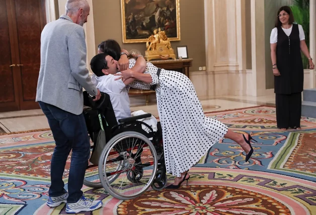 La reina Letizia abrazando a un chico en silla de ruedas.