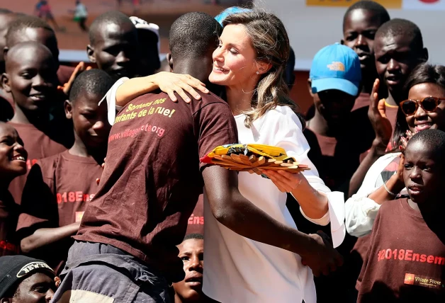 Letizia abrazando a un hombre en África