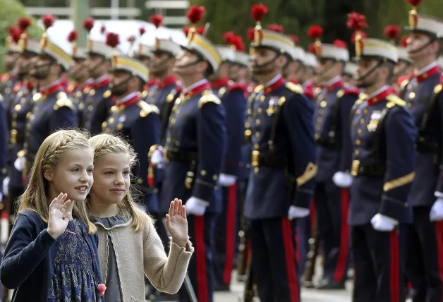 La princesa Leonor y la infanta Sofía saludando durante un desfile.