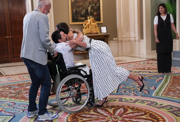 Letizia abrazando a una persona en silla de ruedas.