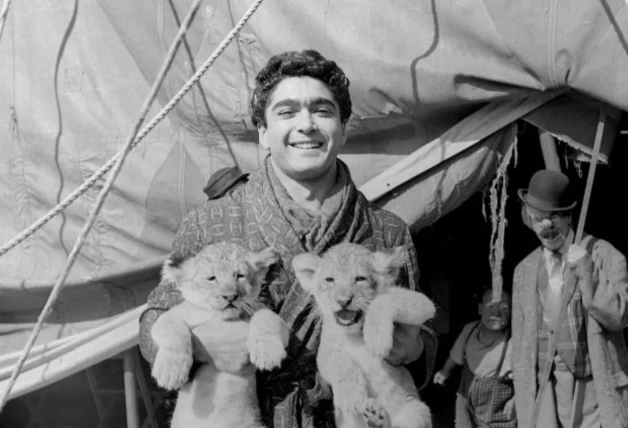 Un jovencísimo Ángel Cristo, cogiendo a dos cachorros de león.