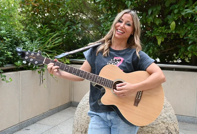 Verónica Romero sosteniendo una guitarra acústica.