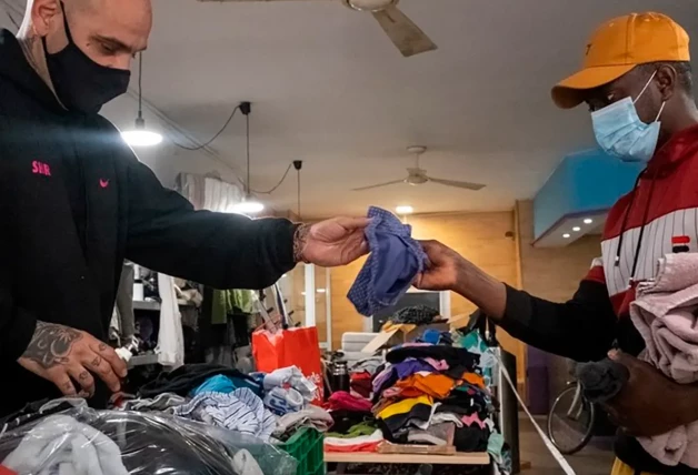 Reparto de ropa limpia en el gimnasio social de Sant Pau.