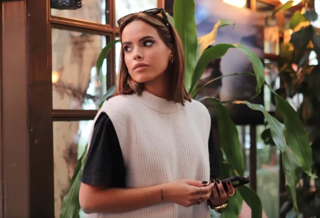 Gloria Camila posando seria en una cafetería.