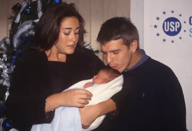 Vicky Martín Berrocal con Alba Díaz bebé en brazos mientras Manuel Díaz le da un beso.
