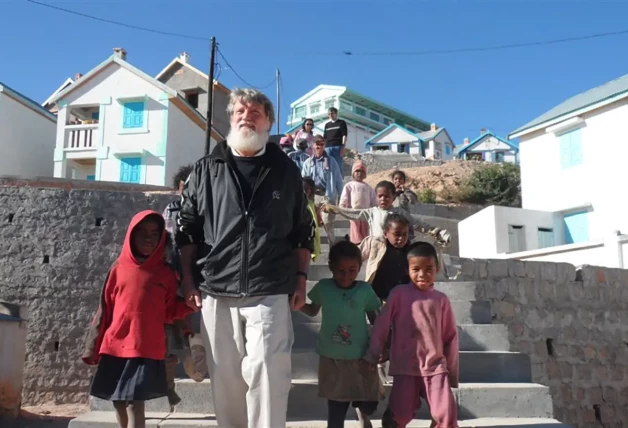 Pedro y un grupo de niños junto a casitas ya habitadas.