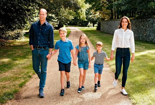 Guillermo de Inglaterra paseando con Kate Middleton y sus tres hijos por un parque.