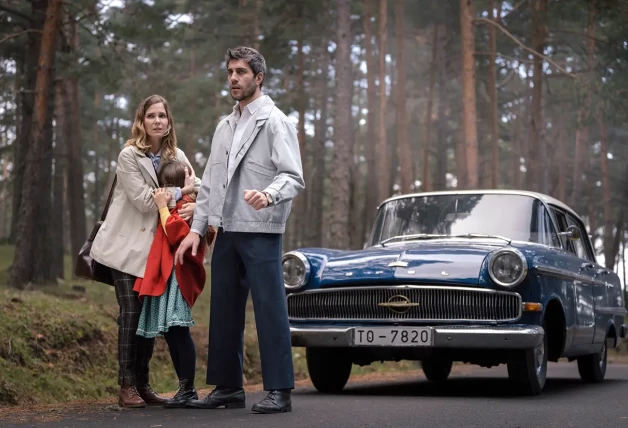 Natàlia Sánchez en una escena de la serie Sueños de libertad abrazando a una niña al lado de un hombre y un coche.