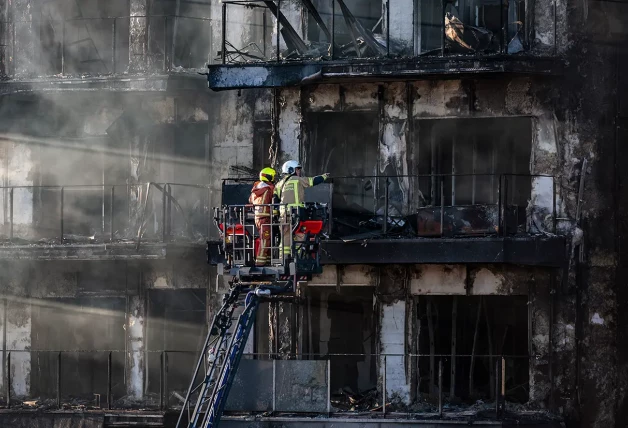 Los bomberos inspeccionan el edificio siniestrado.