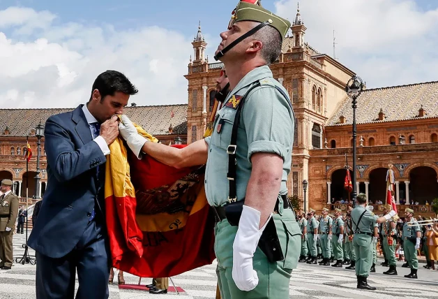 Fran Rivera besa la bandera de España en la Plaza de España de Sevilla.