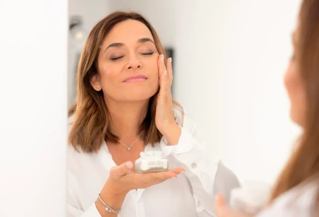 Toñi Moreno aplicándose crema facial delante de un espejo.