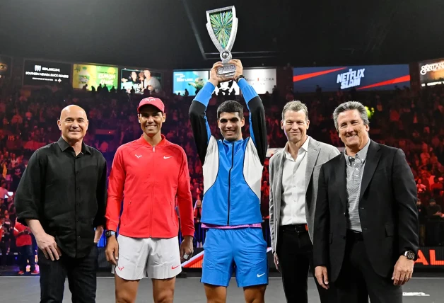 Rafa Nadal junto a Carlos Alcaraz levantando un trofeo.