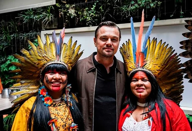 DiCaprio posando junto a dos indígenas.