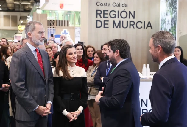 Felipe y Letizia escuchando con las manos entrelazadas.