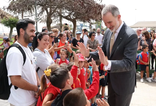 Niños chocan la mano con el rey