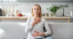 Mujer sentada en un sofá intentando calmar su ansiedad.