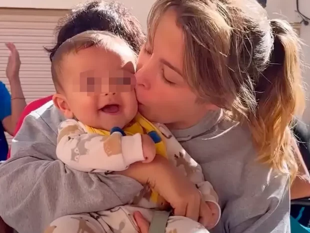 Gisela besando a su bebé Indiana.