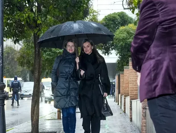 La reina Letizia comparte paraguas con su secretaria, María Ocaña.