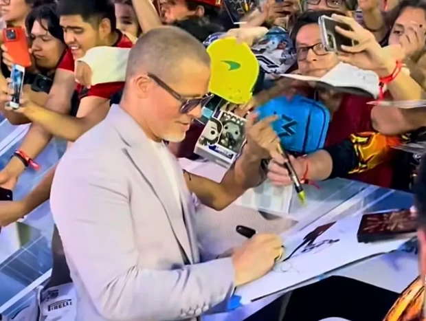 Brad Pitt firmando autógrafos a sus fans