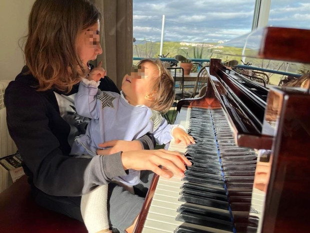 Jan Orozco y su hermanita Antonella frente al piano.