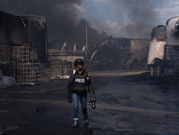 Laura de Chiclana caminando junto al fuego de un bombardeo en Ucrania.