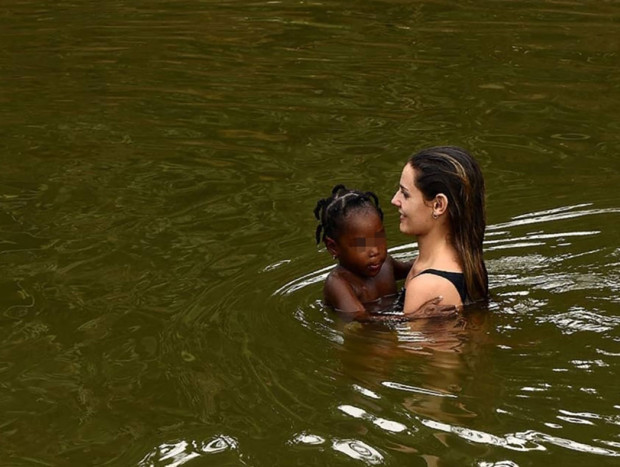 Laura de Chiclana bañándose en un río con una niña en Colombia.
