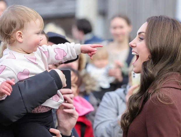 Kate Middleton saludando a un bebé.