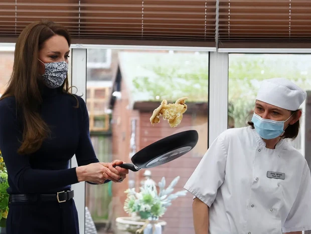 Kate Middleton dando la vuelta a un panqueque cocinado en una sartén
