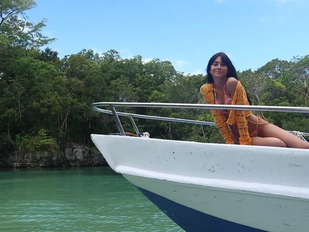 Aitana posando subida a un barco en un río de República Dominicana