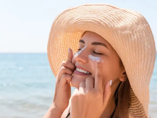 Mujer poniéndose protección solar contra los rayos UVA