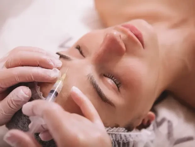 Mujer en medio de un tratamiento estético aplicando botox en la cara
