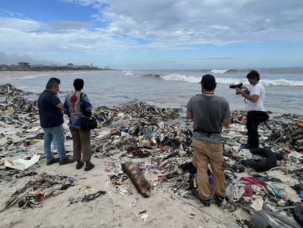 Jalis en una playa de Costa de Marfil totalmente llena de prendas de ropa vieja procedente del primer mundo.