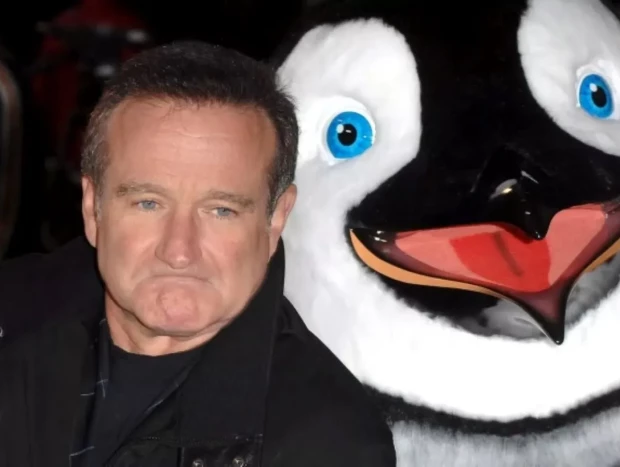 Robin Williams junto a un peluche gigante de un pingüino.