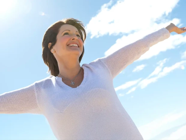 Mujer levantando sus brazos al viento