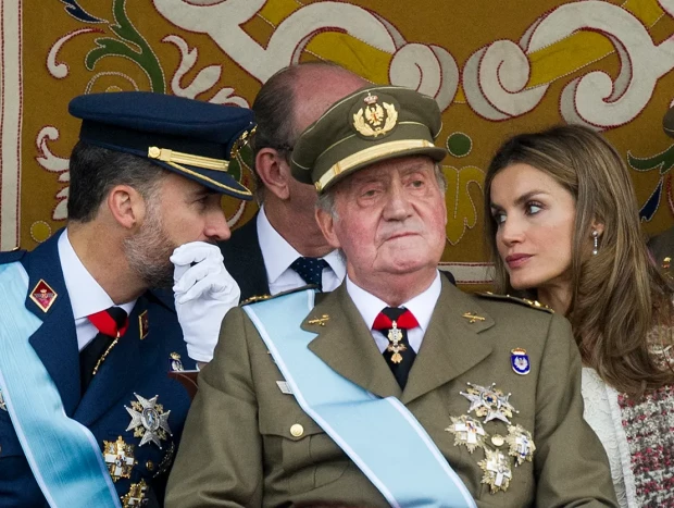 Felipe VI y Letizia hablando por detrás del rey Juan Carlos.