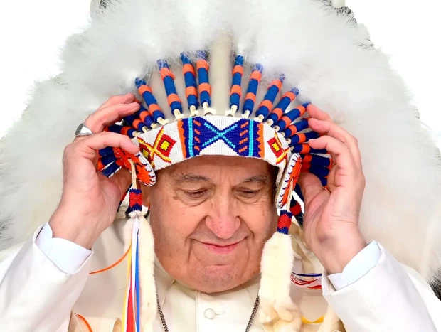 El Papa Francisco portando sobre su cabeza un tocado de plumas de nativo americano.