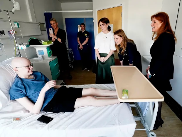 Sarah Ferguson y sus hijas saludando a un paciente de cáncer en un hospital.