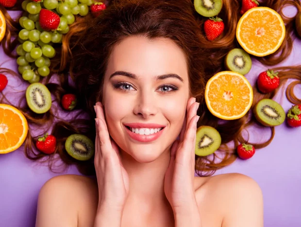 Mujer rodeada de frutas.