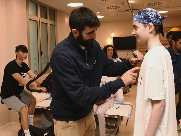 Ricky Rubio firmando la camiseta de un niño enfermo.