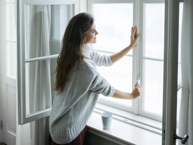 Mujer cerrando una ventana