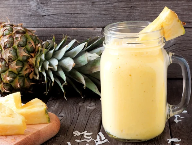 Zumo detox de piña, jengibre y pepino en jarrita con ingredientes frescos