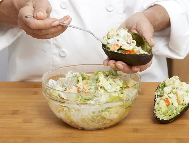 Aguacates rellenos de ensaladilla listos para servir como entrante fresco.