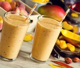 batido de mango y melocotón cremoso en vaso alto