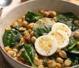 Plato servido de garbanzos con espinacas y huevo duro recién preparado