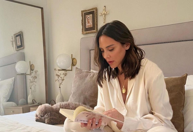 Tamara Falcó leyendo en la cama con un pijama blanco.
