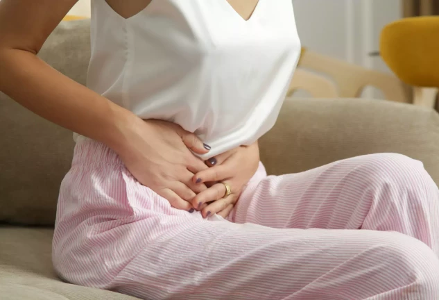 Mujer con malestar estomacal y dolor abdominal