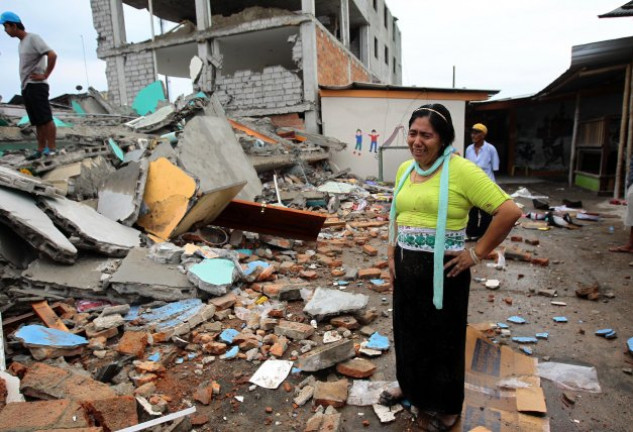 Una mujer llora, con desconsuelo, ante las ruinas de lo que era su casa.