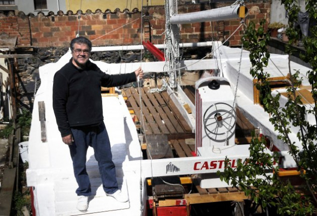 Pepe, de 60 años, junto al catamarán que él mismo ha diseñado y construido en el patio de su casa.
